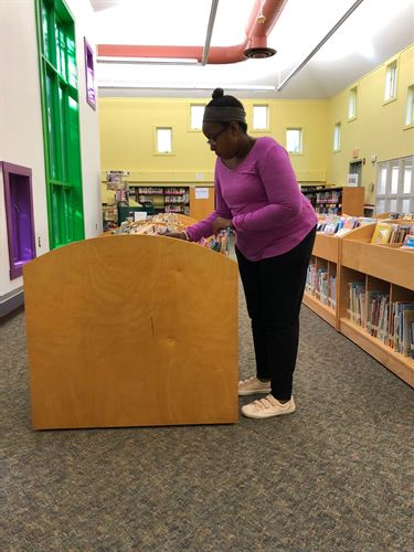 Student organizing books at the library